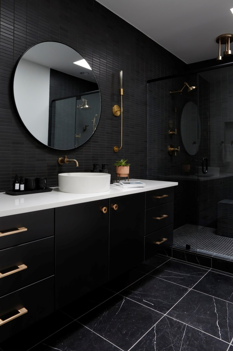 black bathroom with gold hardware and white countertops