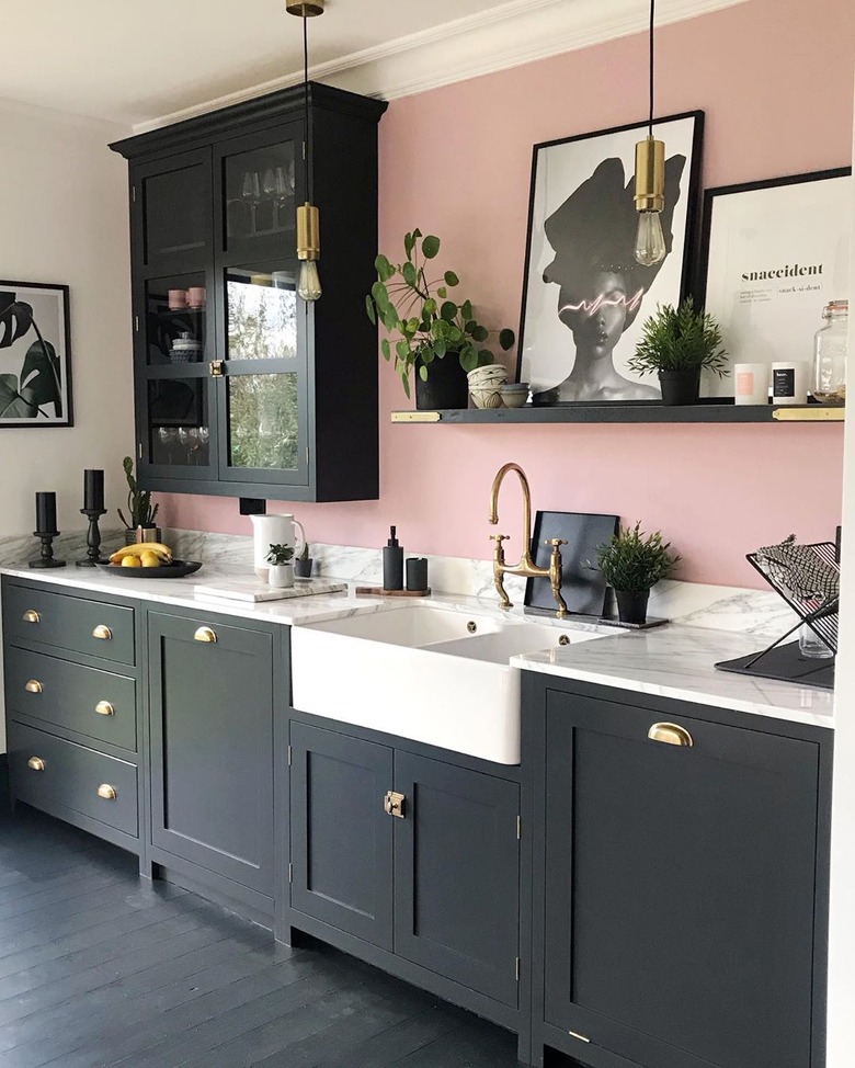 Black kitchen floor in painted wood and featuring a pink wall and modern decor