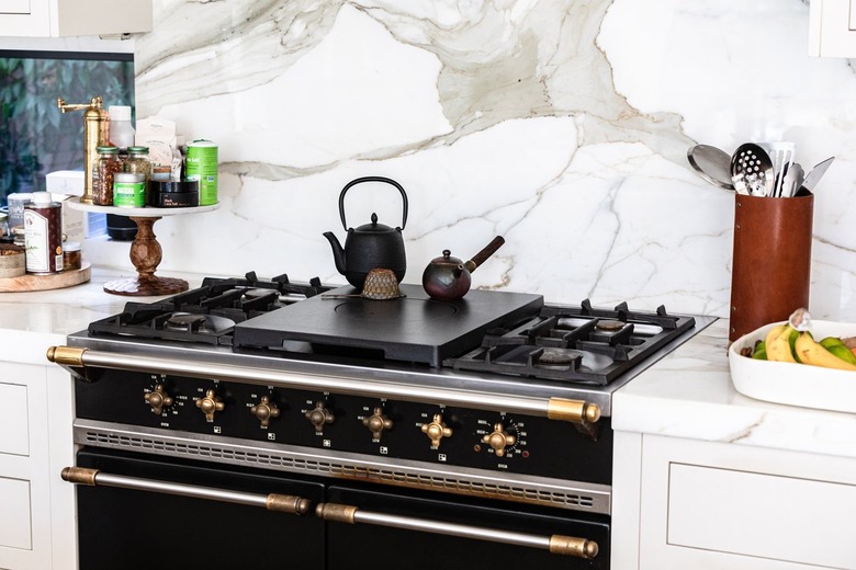 Black Room Ideas with Stovetop with teapots in a kitchen with white countertops and granite backsplash