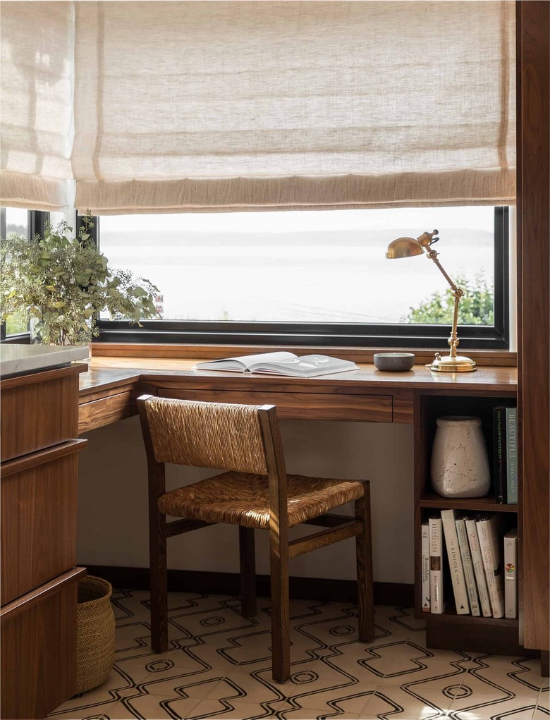 black windows in office with rattan chair and beige Roman shades