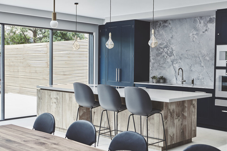 blue and gray kitchen with blue cabinets and blueish gray stone backsplash