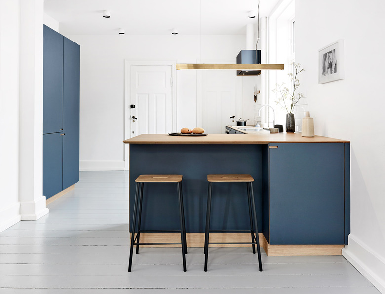 minimal blue and white kitchen with wood countertops and modern stools