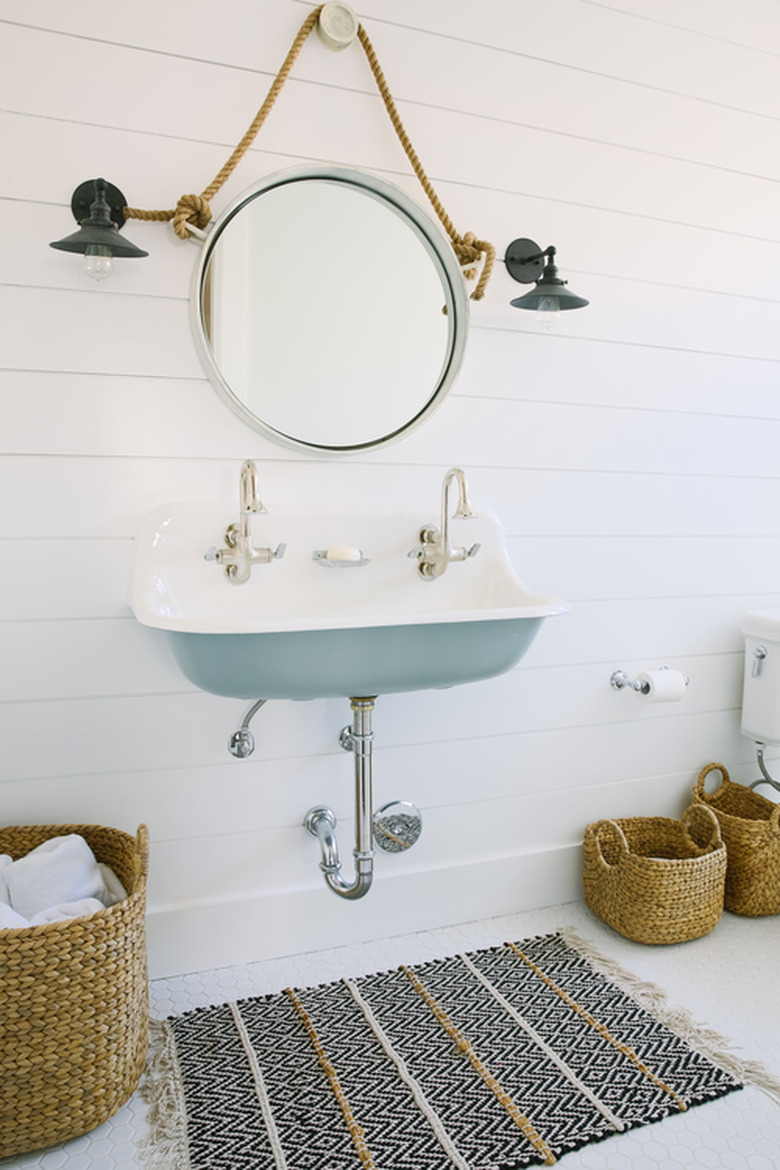 white bathroom with shiplap walls and blue trough sink