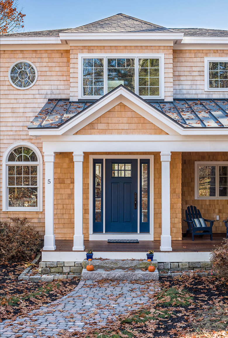 blue home exterior with unstained shingled roof and white accents