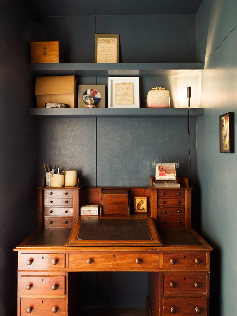 dark blue home office with an antique wooden desk