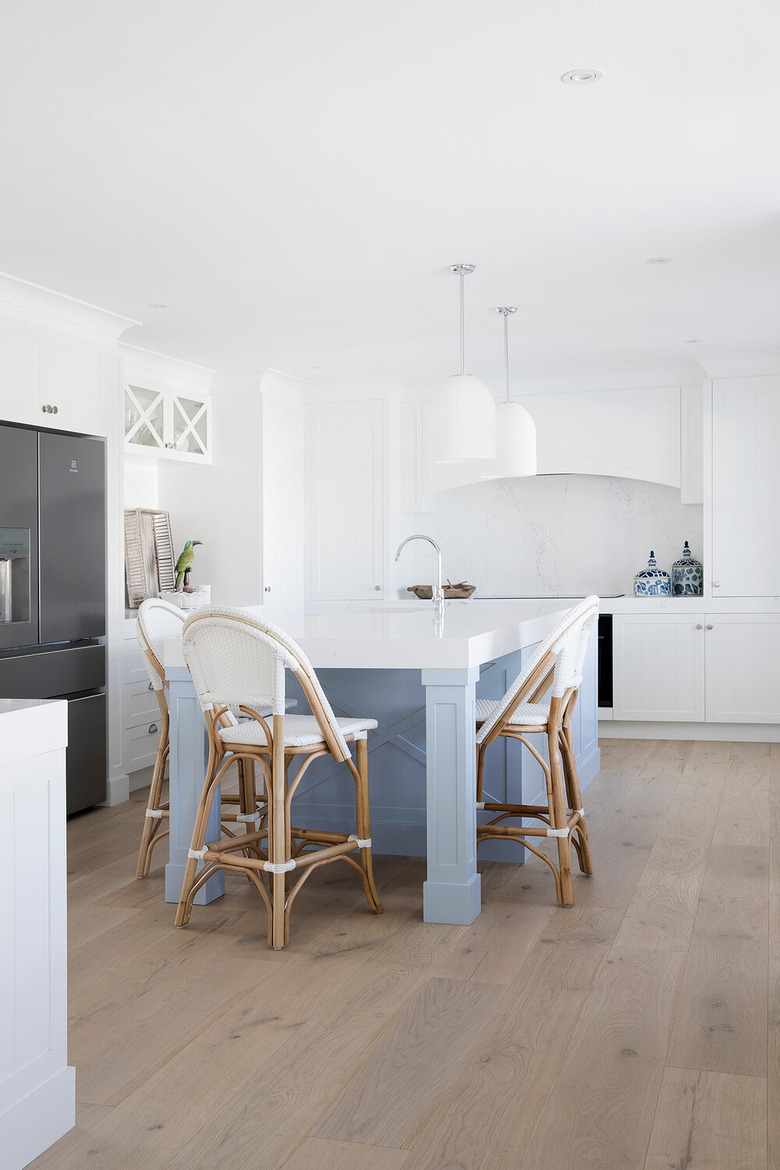 pale blue kitchen island with all white cabinets and countertops