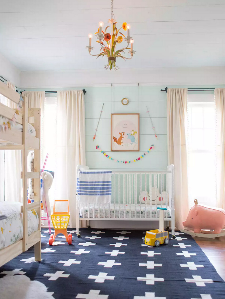 blue nursery idea with aqua shiplap walls and dark area rug