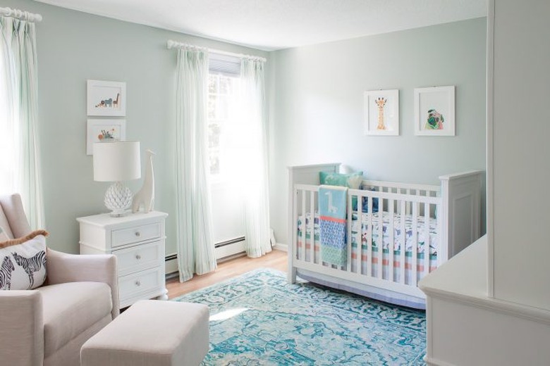 Blue nursery idea with white furniture and blue area rug