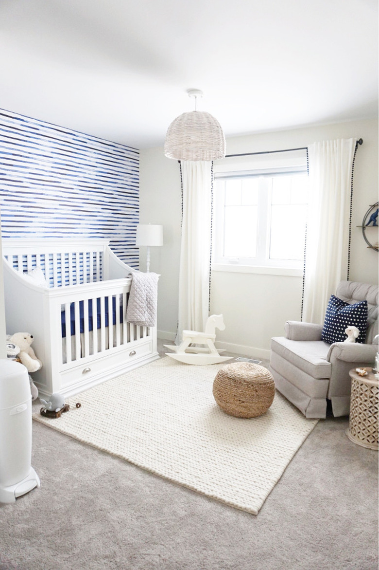 blue nursery idea with white walls and furniture and carpet flooring with area rug