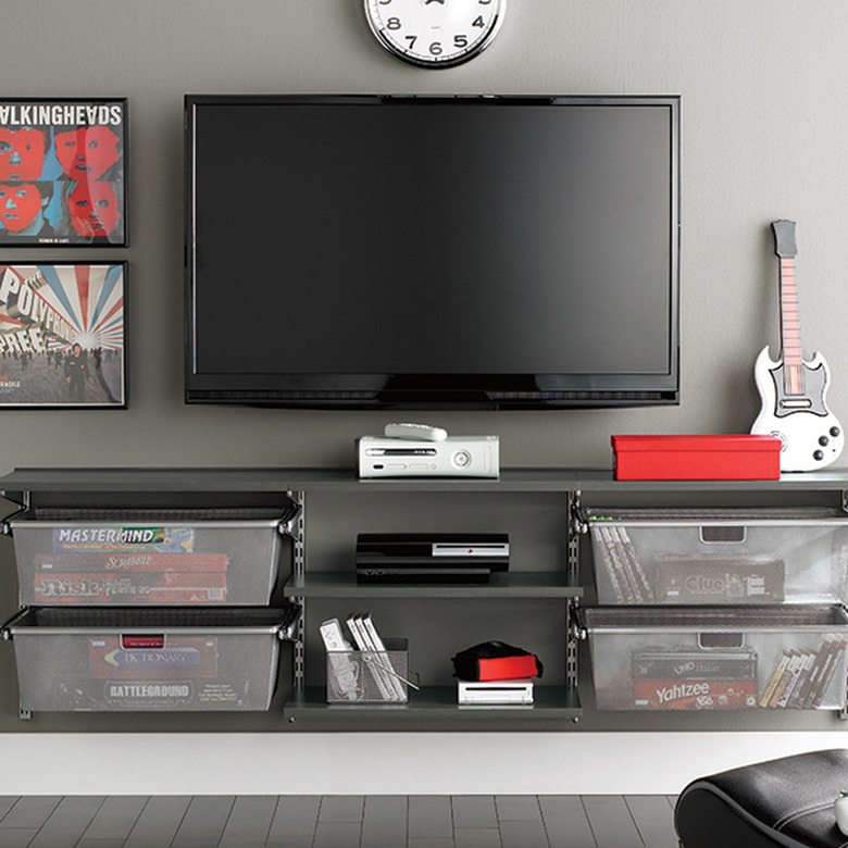 gray walls with media center and TV hanging and board game storage