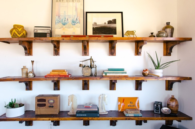 old books, vintage toys, and small pieces of art on rustic wooden shelves