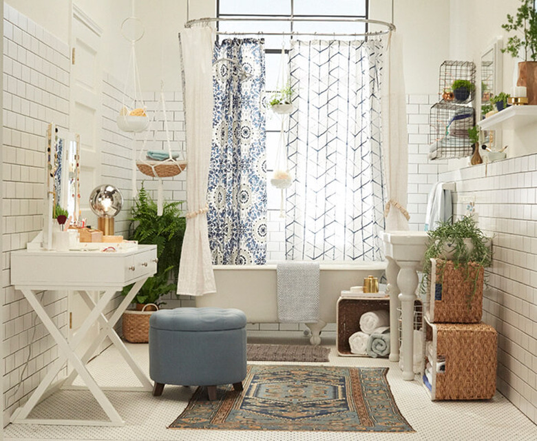 bohemian bathroom idea with subway tile walls and potted plants surrounding clawfoot tub