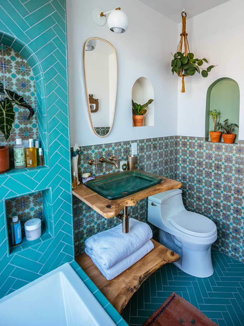 blue-green bohemian bathroom idea with glass vessel sink and live edge wood vanity and patterned wall tile with herringbone floor tile