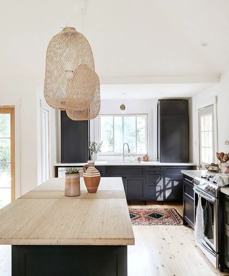 white kitchen with black cabinets and rattan pendants