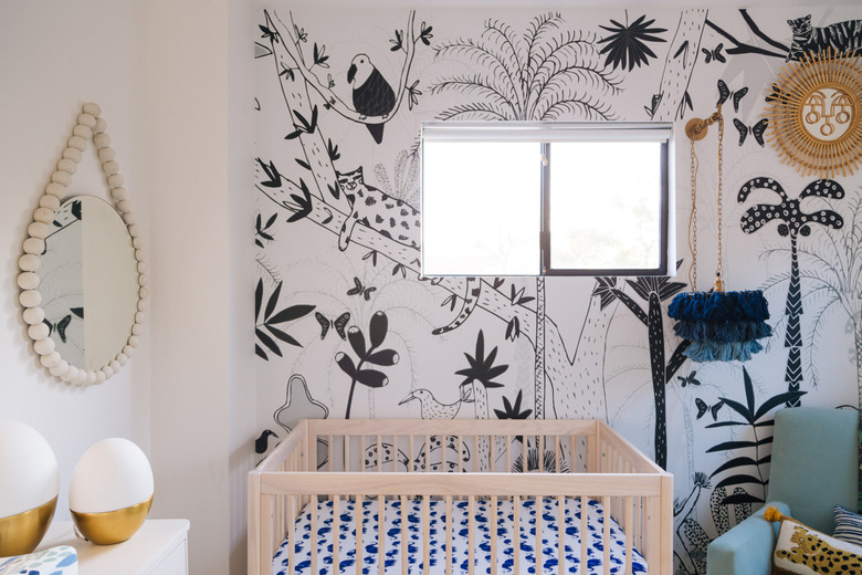 bohemian baby nursery idea with fringe pendant light and animal print wallpaper