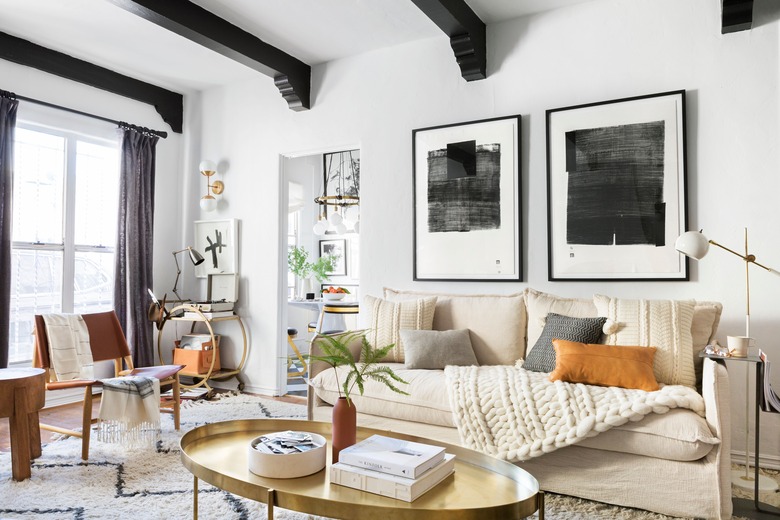 bohemian living room lighting idea with exposed ceiling beams and neutral palette