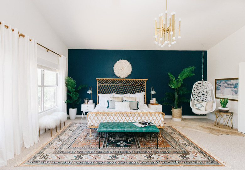 bohemian teal bedroom with feature wall and rattan bed