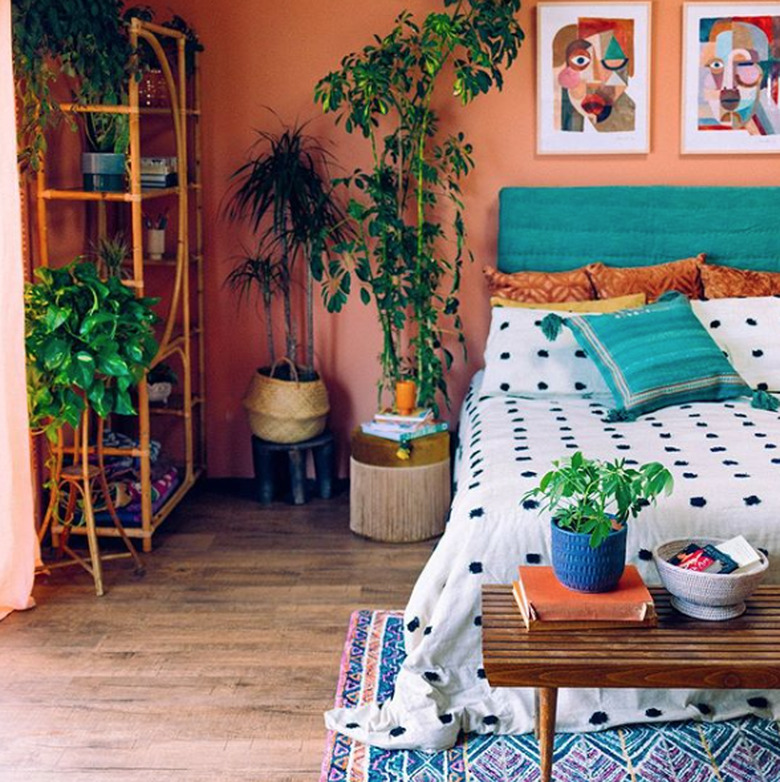 bohemian teal bedroom idea with potted plants and upholstered headboard