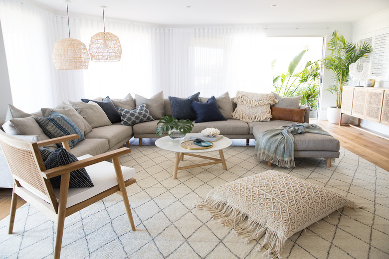 boho coastal living room with large sectional, hanging pendants