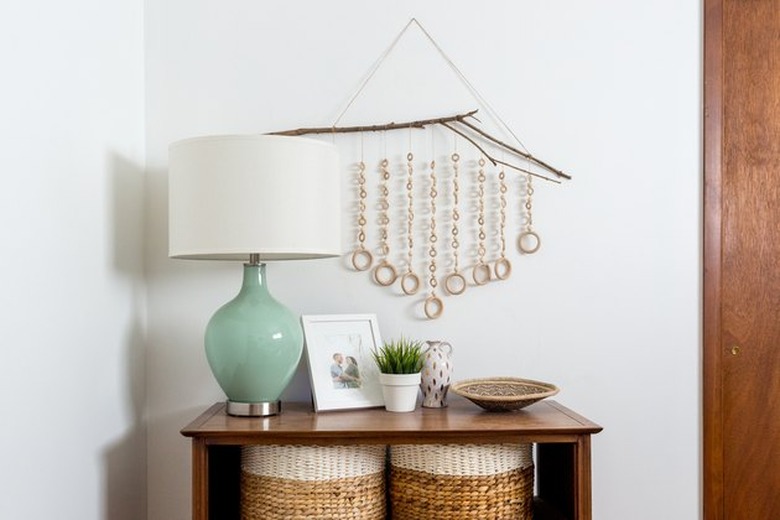 wood wall hanging with table and teal-colored lamp