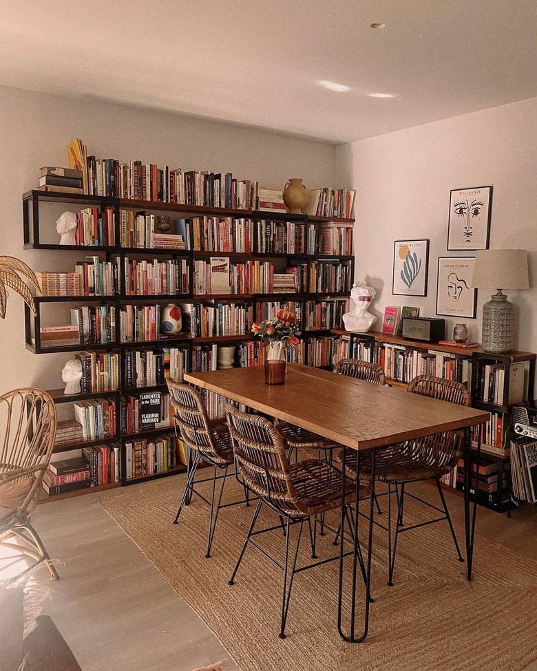 A black bookshelf kitchen with a wooden table and chairs.