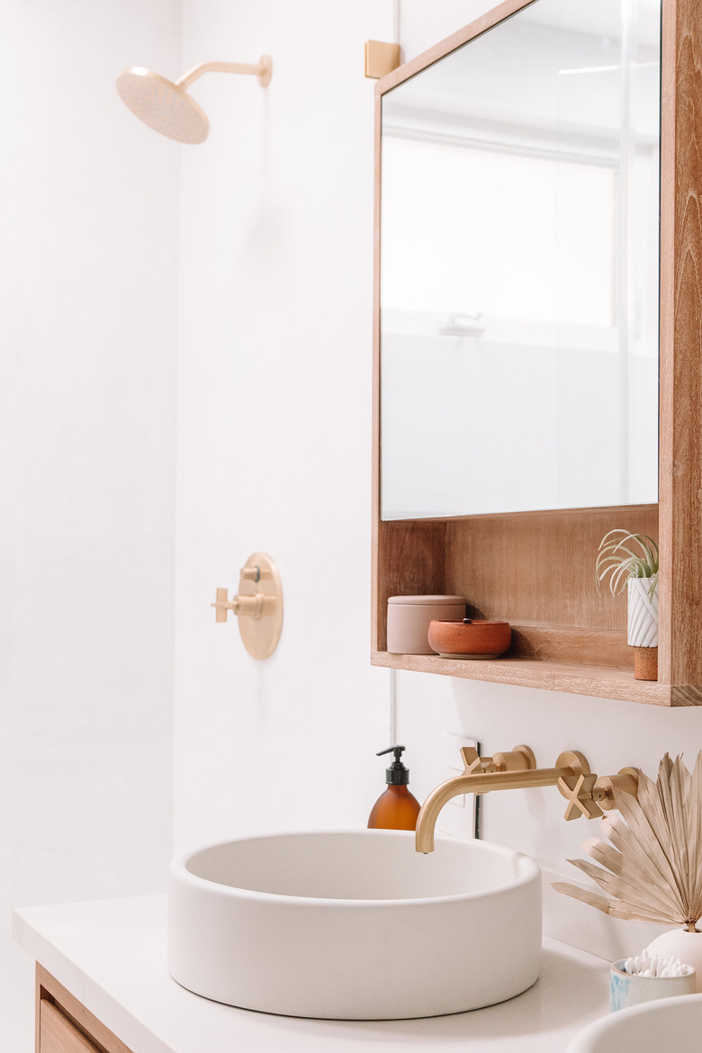 Brass Bathroom Faucet in boho bathroom with circular basin sink and wall mounted brass taps