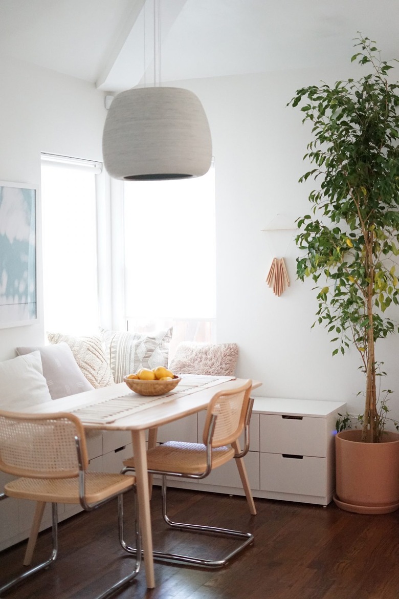 dining room area with white banquette and wicker chairs