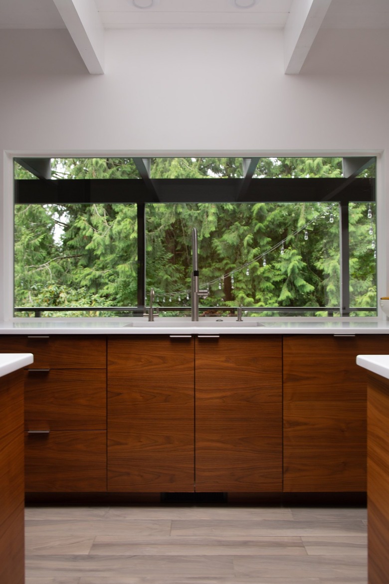 A minimalist contemporary kitchen with wood cabinets and picture windows.