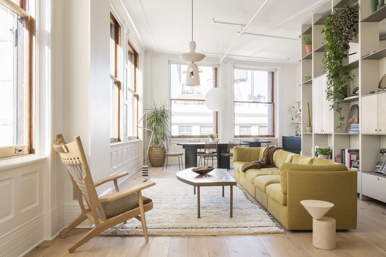 Living room with mustard yellow sofa and floor to ceiling built-in bookcase