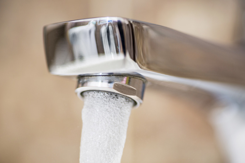 Water flowing faucet. Water tap with flowing water. Selective focus, shallow depth of field. Working water tap