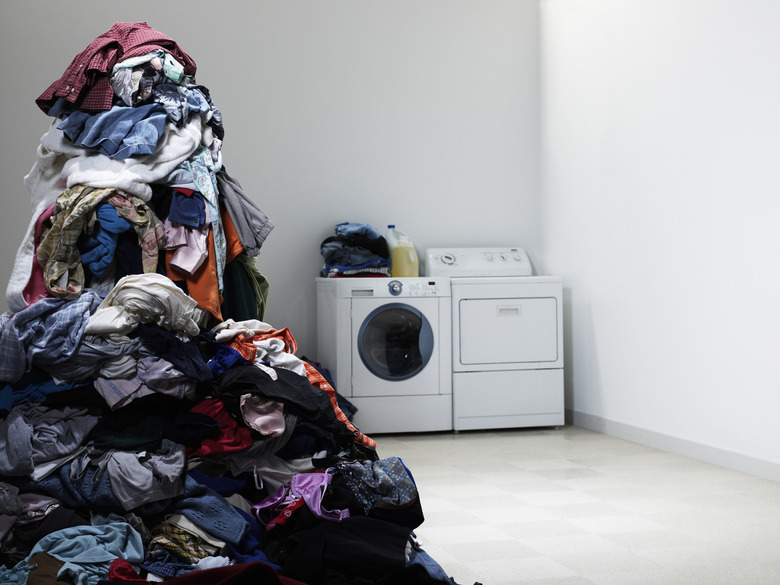 Laundry room with tall pile of clothes.