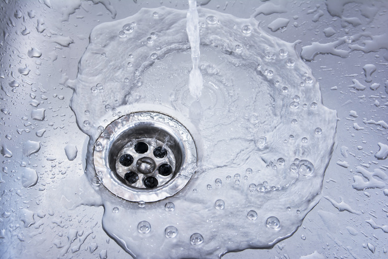 Water draining at sink background. Water flowing drain in washbasin