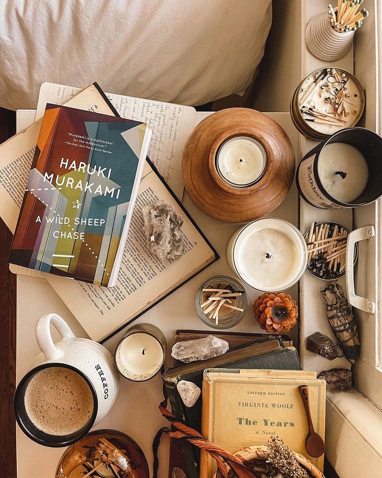 unlit candles surrounding books on desk