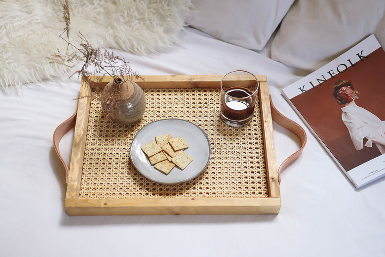 DIY cane webbing tray on bed with wine, crackers and magazine