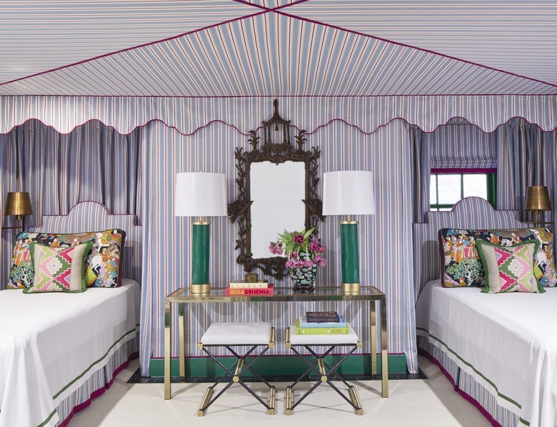 a bedroom tented in pinstriped pale blue and violet fabric