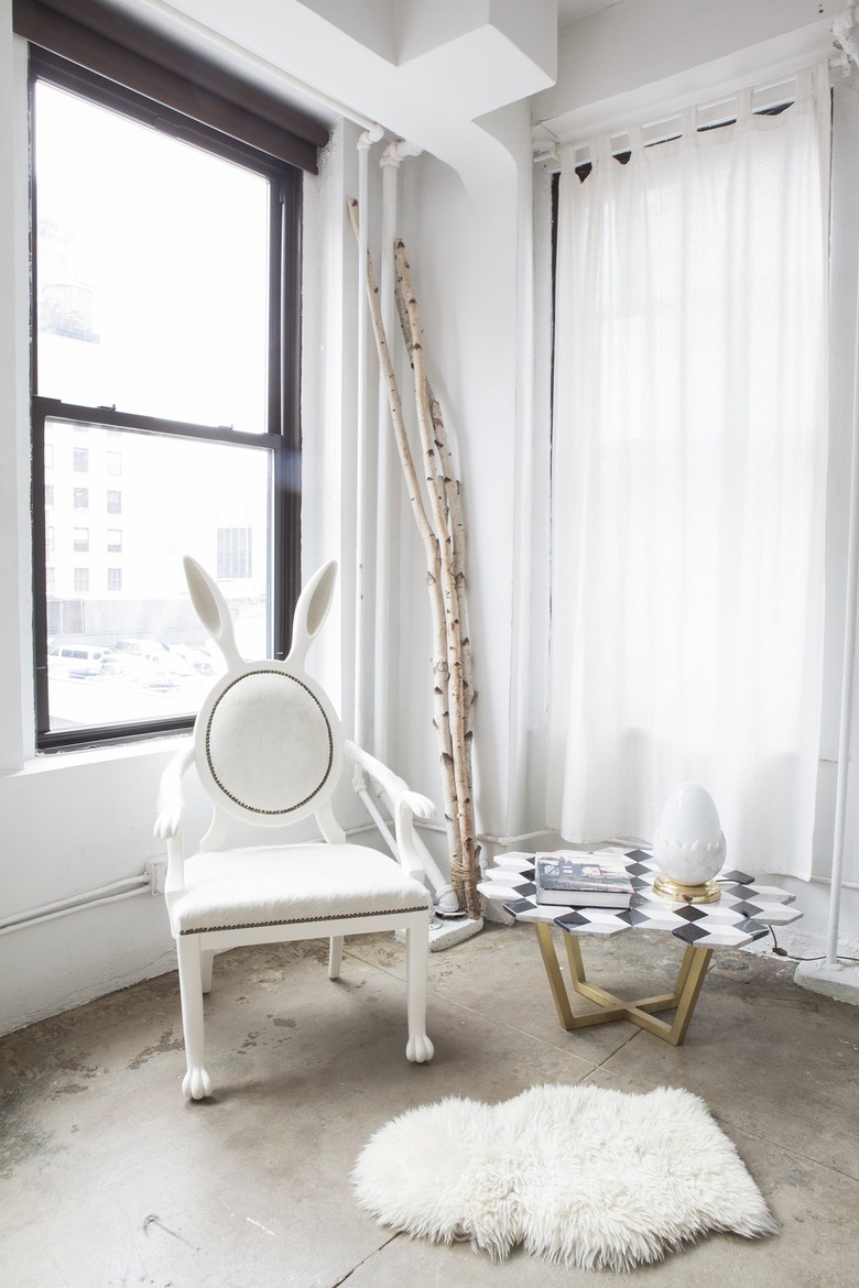 A room with a white hair–upholstered King Louis chair with rabbit ears, arms and feet