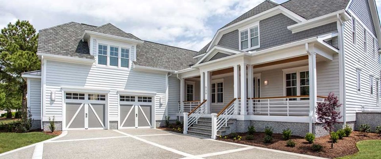 white and gray house exterior with carriage style garage doors