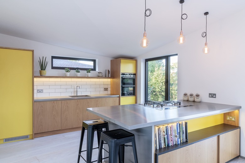 yellow kitchen cabinet idea mixed with wood cabinets and white subway tile backsplash with stainless steel countertops