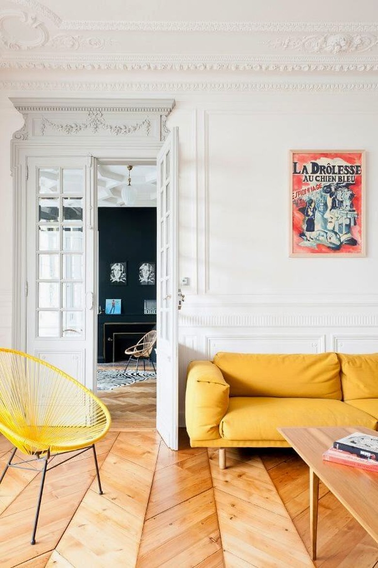 Paris apartment with herringbone wood floors and yellow sofa