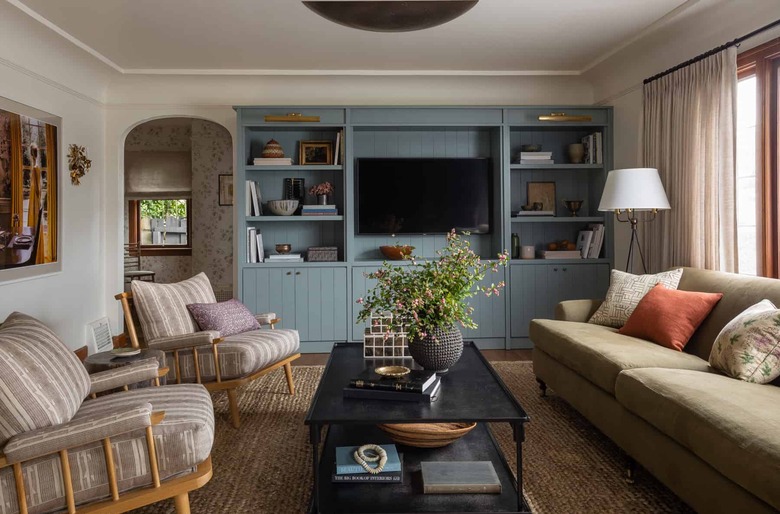 celadon colors on bookcase in living room with vintage rug