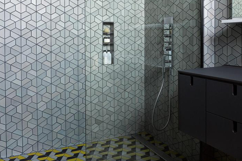 Hexagon tiling in master shower with gunmetal, black, and yellow colors.