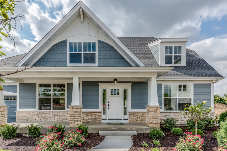 Home with blue siding and stone façade on base of home