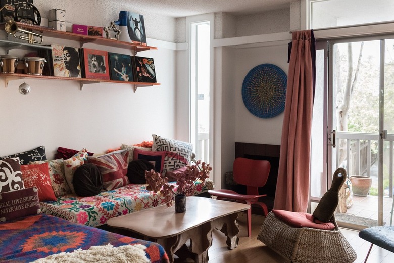 coffee table made from corrugated cardboard by Joel Stearns, wicker rocking chair and brightly patterned couch in bohemian living room