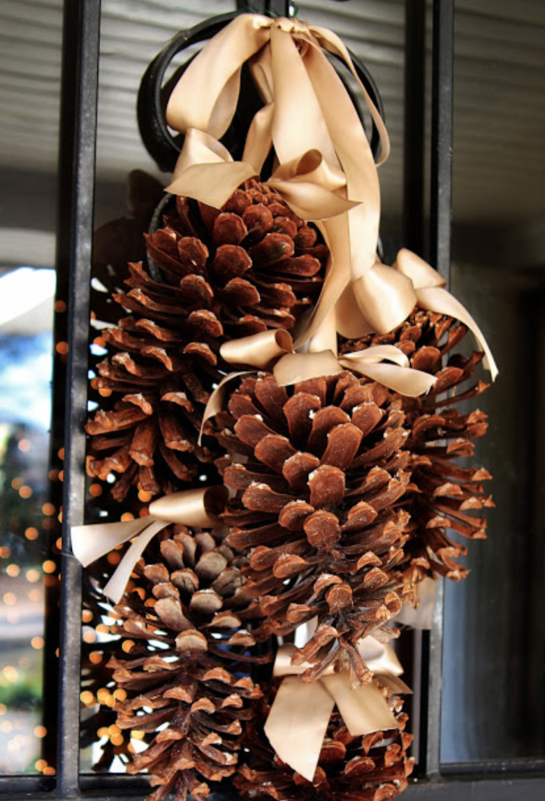 Christmas Door Decorations with Pinecones hung with beige satin ribbon.