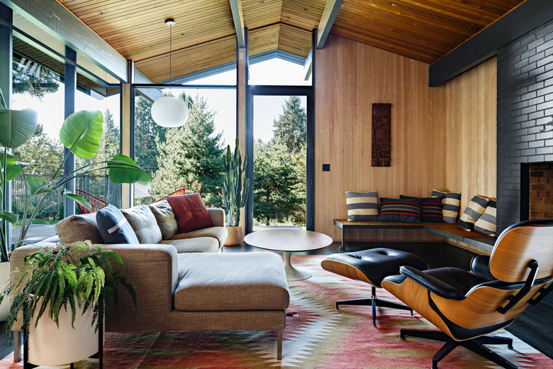 midcentury modern living room with Eames lounge chair and ottoman and black tile fireplace surround