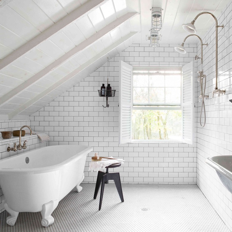 white attic bathroom with clawfoot tub and subway tile backsplash