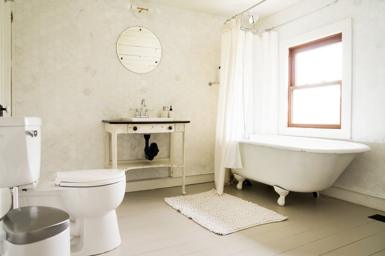 a bathroom with a rustic wooden vanity and a claw-foot tub