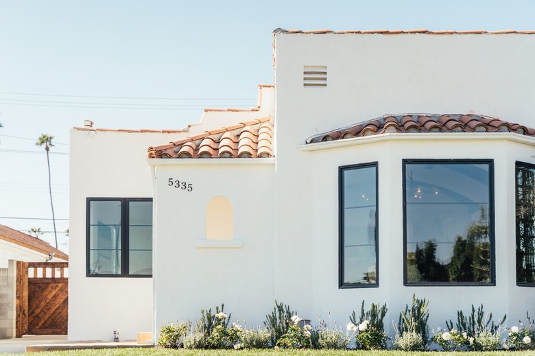 Exterior of white home with spanish tiled roof and black casing windows