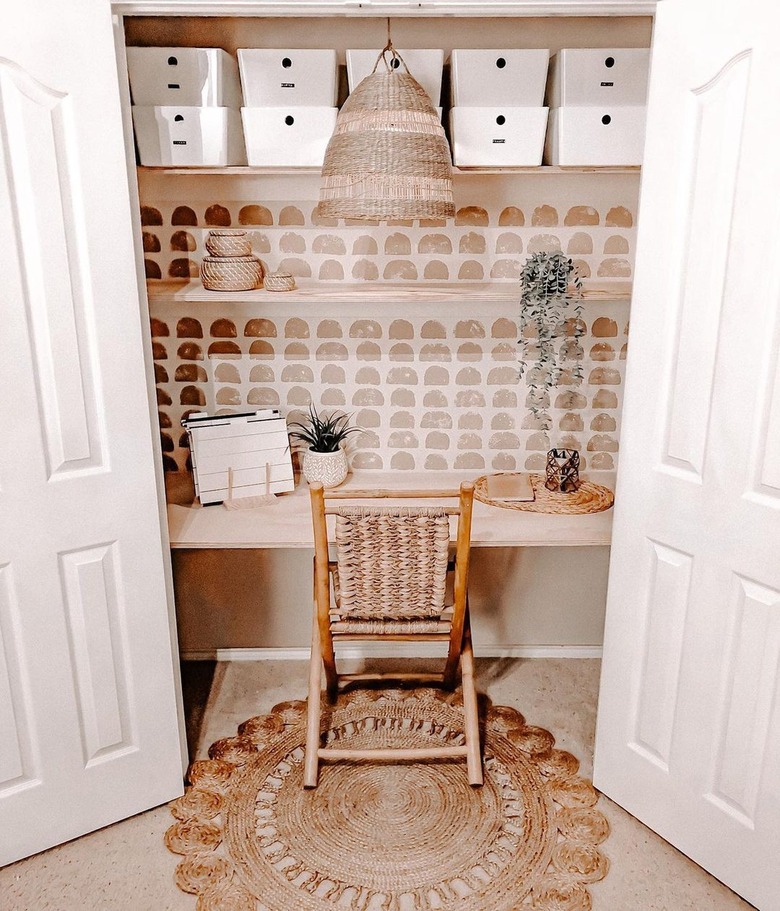 boho closet office with woven pendant lamp and chair, wallpapered accent wall