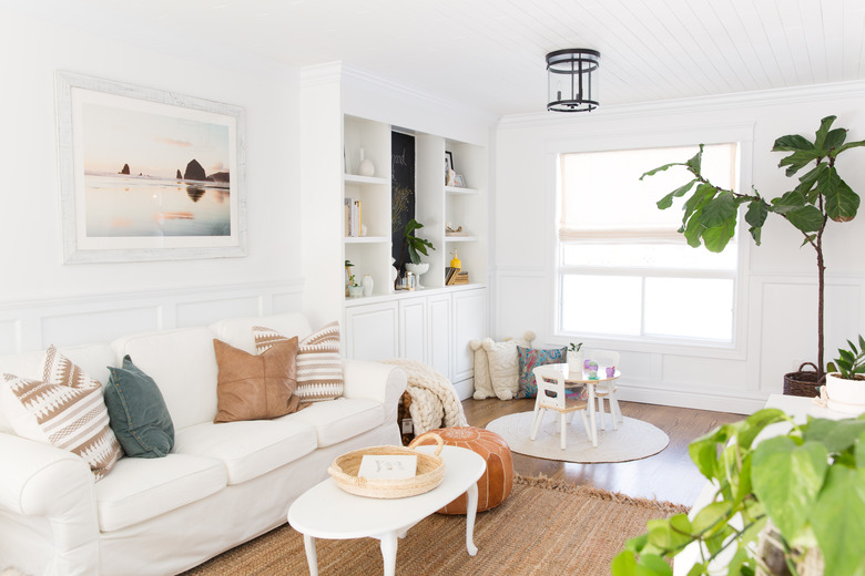 all white coastal family room with storage and jute rug